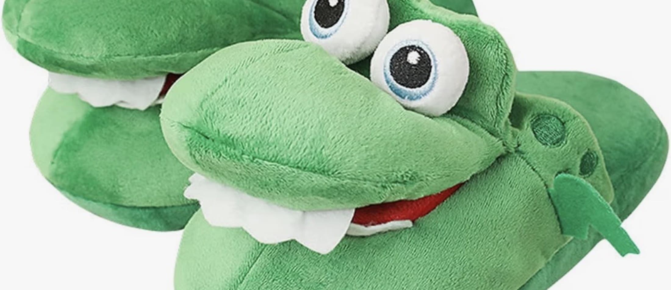 Deux chaussons crocodile en peluche verte, gros yeux et dents blanches.