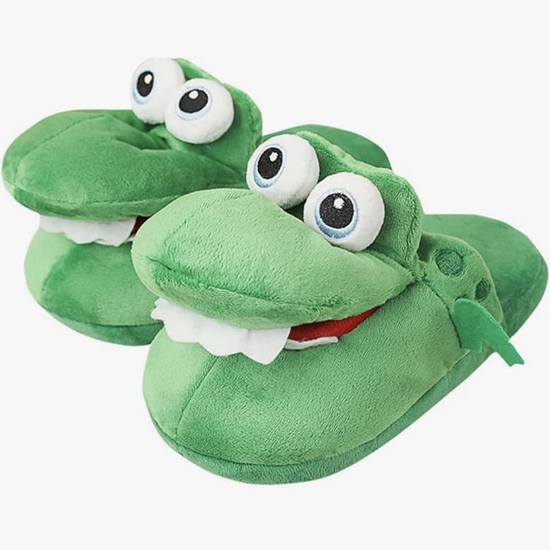 Deux chaussons crocodile en peluche verte, gros yeux et dents blanches.