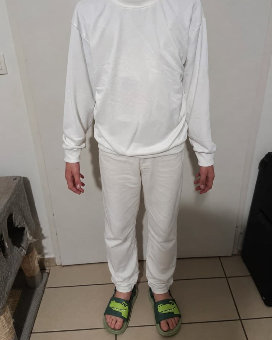 Les claquettes portées avec un ensemble blanc, un crocodile à lunettes sur chaque bride.